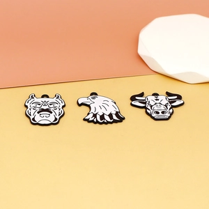 Gros plan de pendentifs en alliage de tête d'animal noir et blanc pour bijoux DIY.