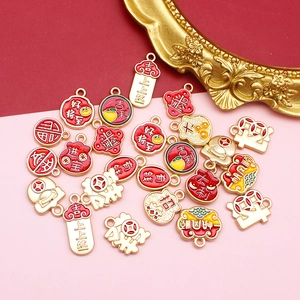 Close-up view of festive Chinese style DIY alloy charms with lucky red enamel drippings
