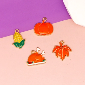 Close-up of Thanksgiving enamel charms featuring turkey, pumpkin, corn, and maple leaf.