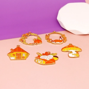 Close-up of Thanksgiving enamel alloy charms featuring turkey, pumpkin, and house designs.