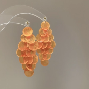 Dettaglio orecchini a frangia con paillettes in conchiglia arancione a strati circolari