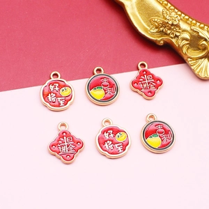 Close-up of Chinese style alloy charms with red enamel and lucky character inscriptions