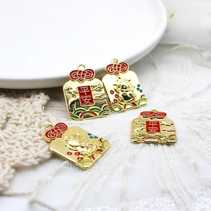 Detail of gold lucky cat charms with red enamel and Chinese character for peace
