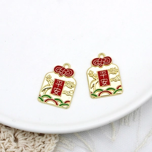 Close-up detail of red and gold alloy peace charms featuring traditional Chinese motifs