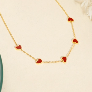 Collier en acier titane doré avec cinq pendentifs cœurs en émail rouge vif