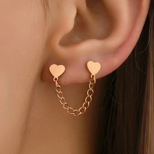 Boucles d'oreilles cœur en or rose avec chaîne pour double piercing sur mannequin