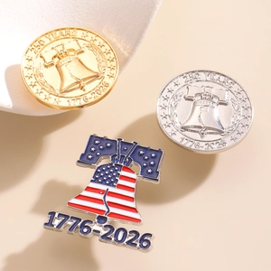 Close-up of gold and silver 250 Years 1776-2026 commemorative badges with Liberty Bell