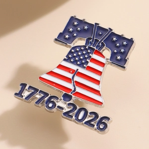 Close-up of Liberty Bell commemorative brooch featuring American flag design and 1776-2026