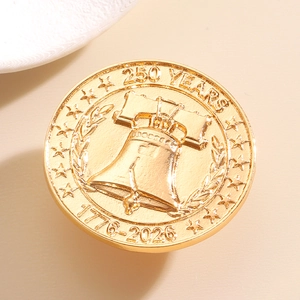 Golden commemorative coin featuring Liberty Bell relief and 1776-2026 anniversary engraving