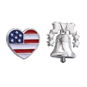 Detailed macro view of USA flag heart pin and 250th anniversary Liberty Bell metal brooch.