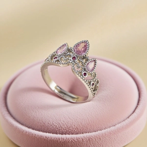 Elegant silver crown ring with pink pear-cut gemstones on a velvet jewelry box