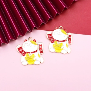 Dettaglio di due ciondoli Maneki-neko in smalto con striscioni fortunati su sfondo rosa