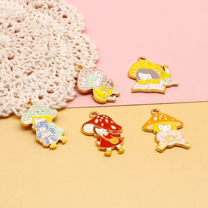 Close-up macro shot of colorful mushroom girl cartoon enamel pendants for DIY jewelry
