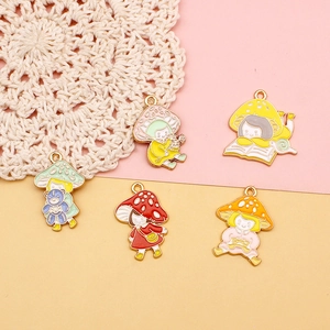 Macro view of five cute cartoon mushroom girl enamel charms for DIY jewelry making.