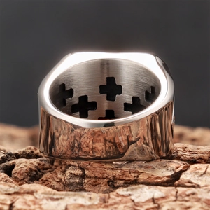 Polished stainless steel cross signet ring with vintage finish on rustic wood
