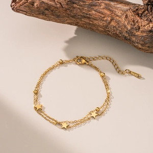 Close-up of double-layer stainless steel anklet with gold stars and round beads