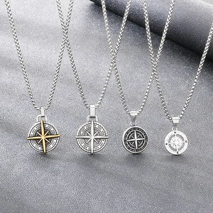 Detailed macro view of four vintage stainless steel compass and nautical star pendants