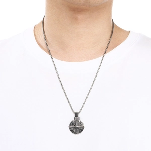 Detail view of a vintage stainless steel compass pendant necklace on a male model