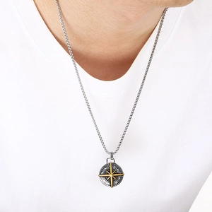 Detailed view of a punk-style stainless steel compass coin pendant worn by a male model