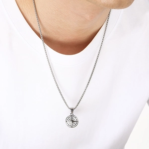 Detailed view of a men's vintage stainless steel compass pendant necklace on a model.