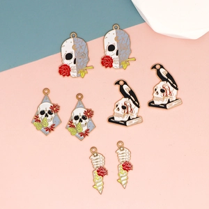 Detalle de varios dijes de esmalte de Halloween con calaveras, cuervos y rosas