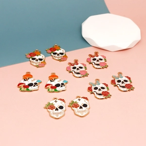 Vista detallada de dijes de calavera para Halloween con diseños de rosas y mariposas.