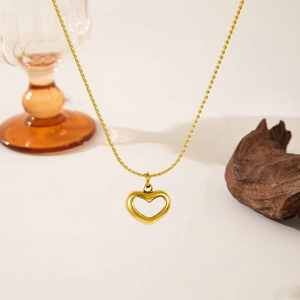 Golden heart pendant necklace with twist chain displayed against a warm retro background