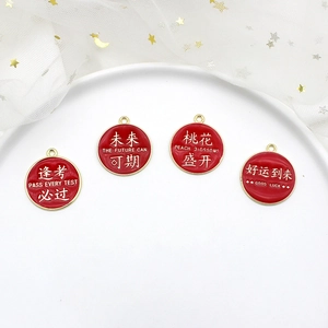 Detailed macro view of red enamel alloy charms featuring Chinese and English blessings