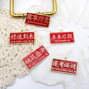 Close-up of red enamel alloy charms with gold Chinese blessing inscriptions for DIY crafts