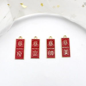 Detail view of red enamel blessing pendants with Chinese characters for DIY jewelry