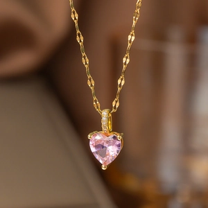 Gros plan d'un pendentif cœur en cristal rose sur une chaîne plaquée or 18 carats