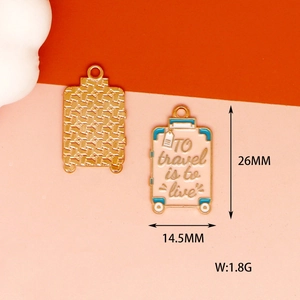 Detailed view of suitcase alloy pendant with To travel is to live text and dimensions