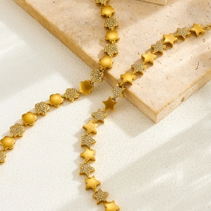 Elegante gouden ster en bloem armband met fonkelende kristallen en matte afwerking