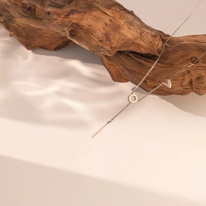 Minimalist LOVE letter pendant necklace with vertical bar on natural wood background