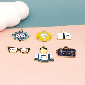 Close-up detail of mixed Father's Day enamel alloy charms featuring DAD motifs for DIY jewelry.