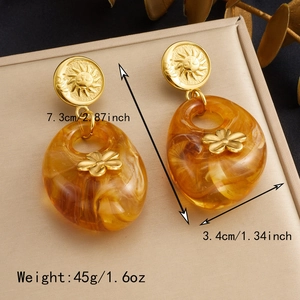 Detail view of large vintage amber resin drop earrings with golden sun texture and dimensions
