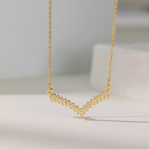 Elegant gold V-shaped chevron necklace with sparkling zircon pavé on a fine link chain
