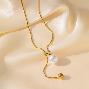Elegant gold snake chain necklace with pearl and round bead on champagne silk background