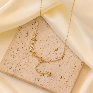 18k gold plated hollow star necklace with tassel pendant on elegant travertine