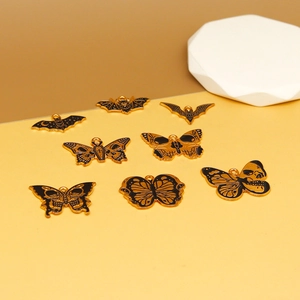 Detail van zwarte en gouden gotische emaille vlinder- en vleermuisbedeltjes voor sieraden