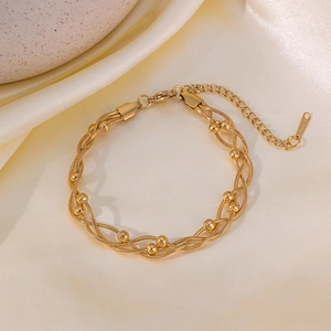 Multilayer gold stainless steel chain bracelet with beaded accents on silk fabric