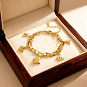 Bracelet double rang doré avec breloques papillon et étoile dans un coffret en bois velours