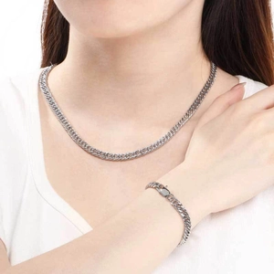 Vue détaillée d'un ensemble collier et bracelet maille gourmette argentée sur modèle