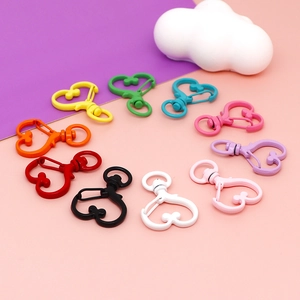 Colorful heart-shaped lobster clasps for DIY jewelry and keychains displayed on pink background