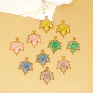 Detailed view of various colorful alloy enamel maple leaf charms for DIY jewelry making.