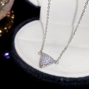 Vue macro d'un pendentif triangle géométrique avec pierres pavées scintillantes