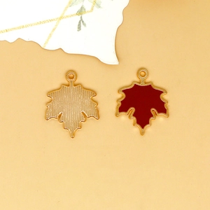 Detail showing red enamel maple leaf alloy charm with gold-tone back and top ring