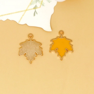 Detail view of yellow enamel maple leaf charms for DIY jewelry making accessories