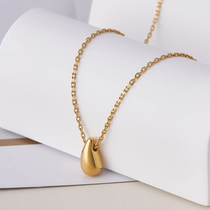 Gros plan du pendentif goutte d'eau en or 18k sur chaîne O avec finition polie miroir