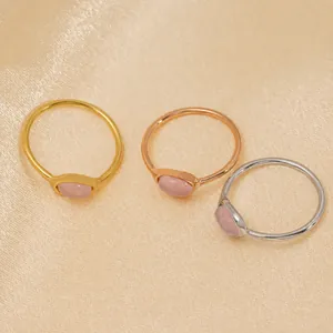 Détails des pierres de quartz rose serties sur des bagues en acier en trois finitions.